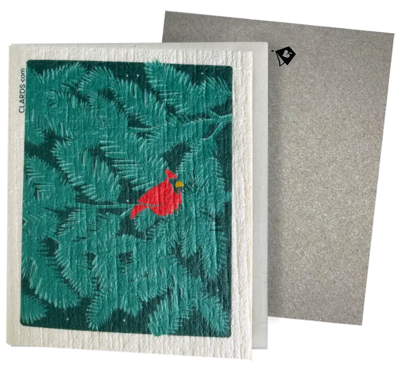 A red cardinal on teal pine branches on a white embossed eco greeting card turns into reusable swedish sponge cloths