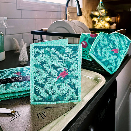Teal and pink holiday reusable swedish sponge with cardinal bird and pine branch design from soak it up clards greeting card turns