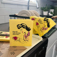 Load image into Gallery viewer, Bright yellow reusable swedish sponge cloth with retro woman holding jam bread from soak iT up clards collection
