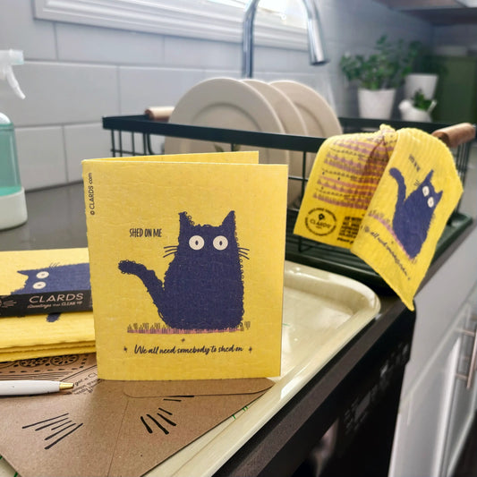 Yellow clards reusable swedish sponge cloth with navy blue cat illustration and shed on me text for cleaning use