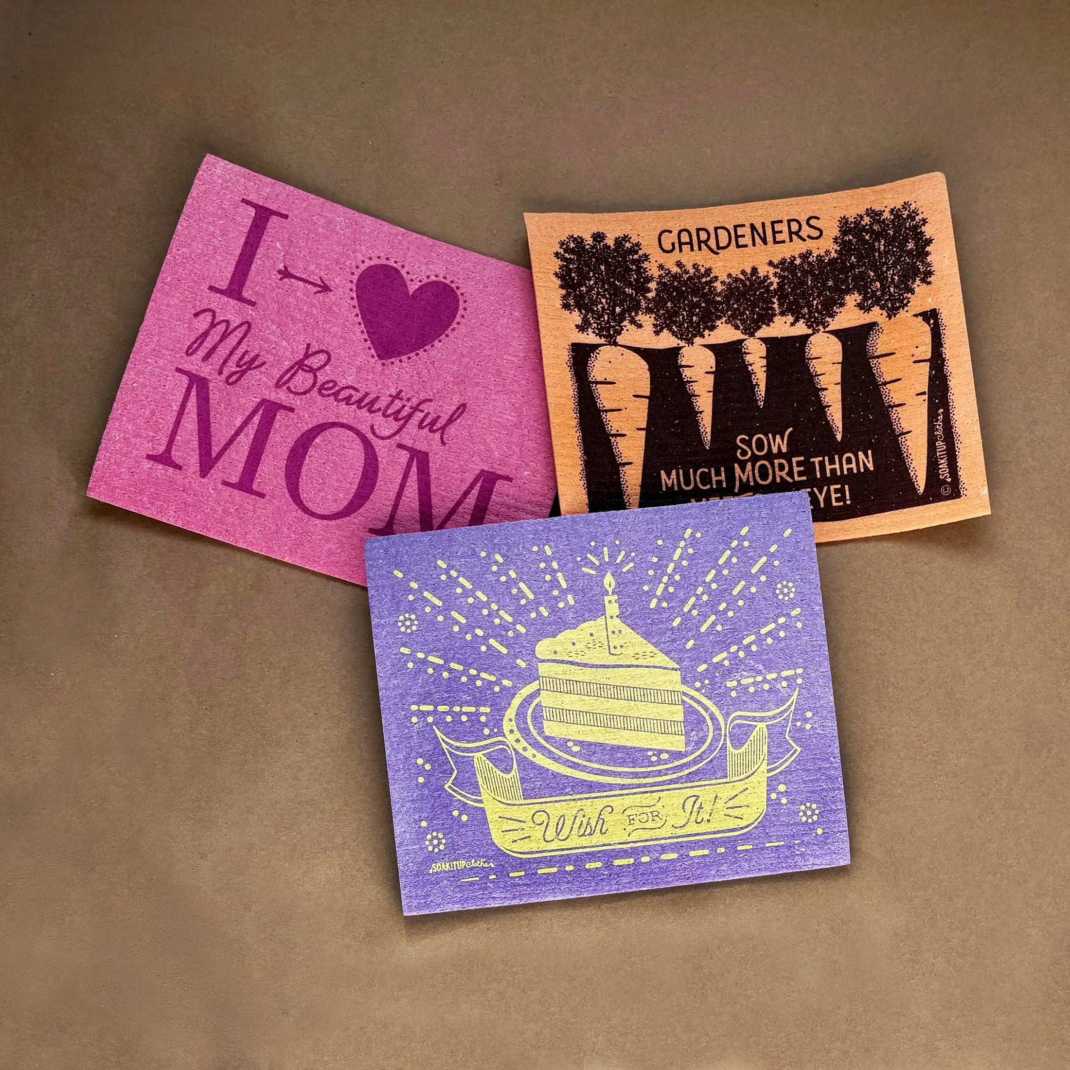 Three colorful textured reusable swedish dishcloths with printed designs in pink orange and purple best selling swedish dishcloths