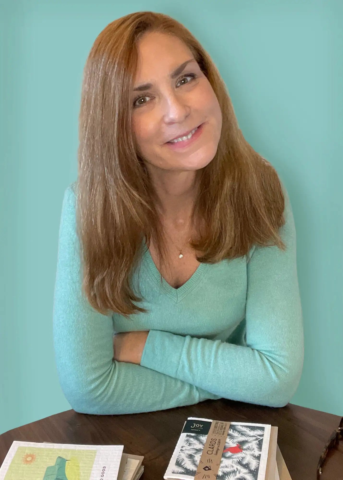 Woman wearing a light teal long-sleeved v-neck sweater